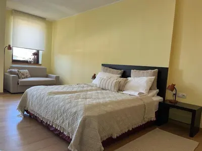 a bedroom with a large bed and a couch at Rilets Studio in Borovets