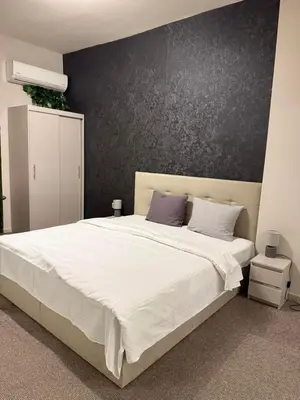 a bedroom with a large white bed with a black wall at Top Center Apartment Sofia in Sofia
