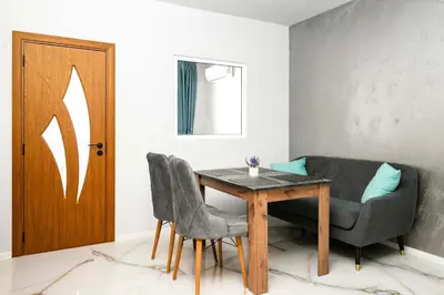 a dining room with a table and chairs and a door at Stylish 1 Bedroom Apartment - Quiet & Comfortable in Sofia