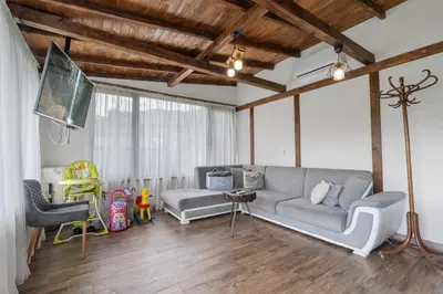 a living room with a couch and a tv at Къща за гости Мартинели