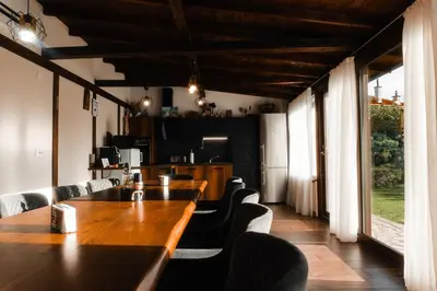 a dining room with a wooden table and chairs at Къща за гости Мартинели