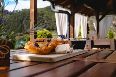 a table with a plate of blueberry turnovers and a drink at Къща за гости Мартинели