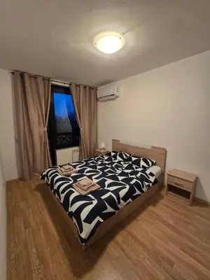 a bedroom with a black and white bed with a window at AspenValley Aprtment in Razlog