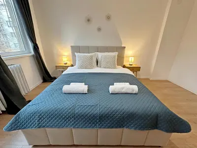 a bedroom with a large bed with towels on it at Spacious bright cozy 2BDR fast Wi-Fi next to Park in Sofia