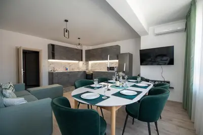 a dining room with a table and green chairs at Apartments by the river 2 in Plovdiv