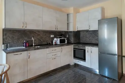 a kitchen with white cabinets and a stainless steel refrigerator at Apartments by the river 2 in Plovdiv