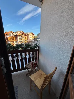 a balcony with a bench and a table with wine glasses at Smart Stay - Refurbished Studio with Balcony and Parking in Bansko