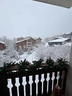 a white fence with christmas trees and snow at Smart Stay - Refurbished Studio with Balcony and Parking in Bansko