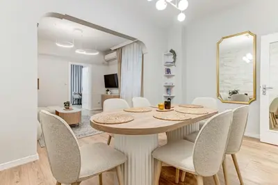 a dining room with a table and chairs and a mirror at Prime Central Sofia Living Modern 2BR Apt in Sofia