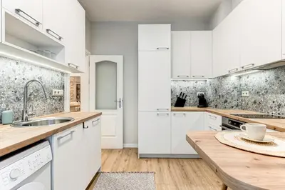 a kitchen with white cabinets and a wooden counter top at Prime Central Sofia Living Modern 2BR Apt in Sofia