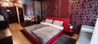 a bedroom with a red bed and a mirror at Iceberg Studio 15 in Borovets