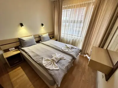 a bedroom with a bed with two towels on it at Belmont urban one bedroom apartment in Bansko
