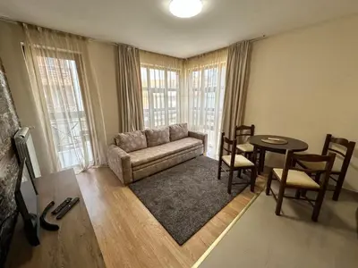 a living room with a couch and a table at Belmont urban one bedroom apartment in Bansko