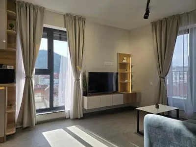 a living room with a tv and large windows at Plovdiv Hills Apartments with FREE Parking in Plovdiv