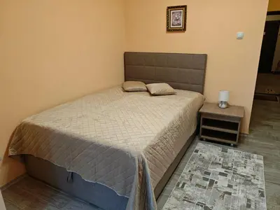 a bedroom with a bed and a table with a night stand at Apartment M 1 in Plovdiv