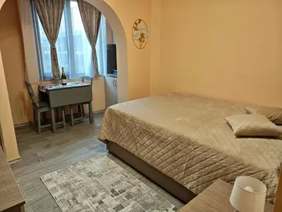 a bedroom with a bed and a desk and window at Apartment M 1 in Plovdiv
