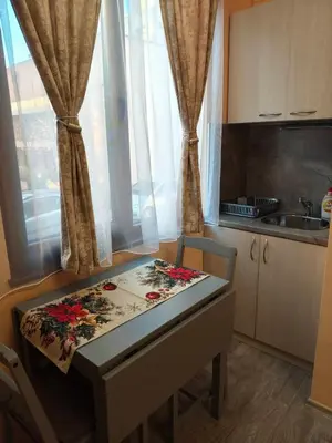 a small kitchen with a table and chairs and a window at Apartment M 1 in Plovdiv