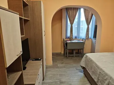 a bedroom with a bed and a desk and a window at Apartment M 1 in Plovdiv