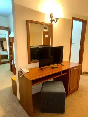 a room with a desk with a television and a mirror at Еmerald Apartment Complex in Bansko