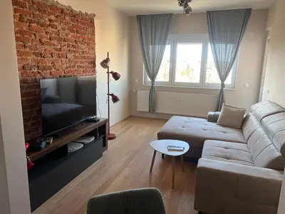 a living room with a couch and a brick wall at Lux, Spacious and Comfort Apartment next to National Palace of Culture in Sofia