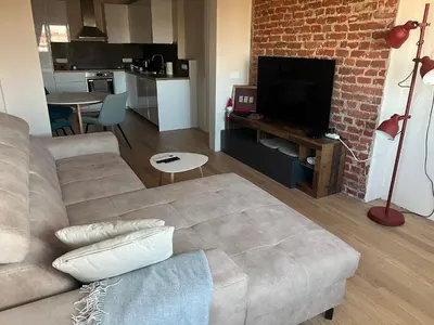 a living room with a couch and a brick wall at Lux, Spacious and Comfort Apartment next to National Palace of Culture in Sofia
