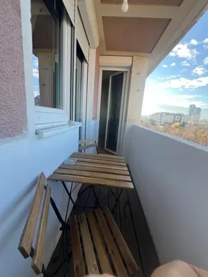 two wooden benches sitting on a balcony with a window at Lux, Spacious and Comfort Apartment next to National Palace of Culture in Sofia