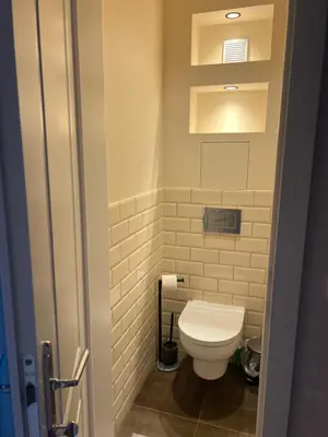 a bathroom with a white toilet in a room at Lux, Spacious and Comfort Apartment next to National Palace of Culture in Sofia