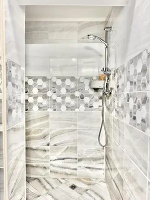 a bathroom with a shower with white tiles at Top City Centre 1BDR Apartment next to Theater Tear and Laughter in Sofia