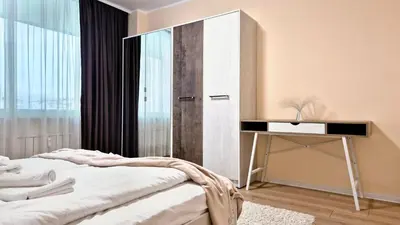 a bedroom with two beds and a table and a mirror at Spacious 3 BDR City Pulse near Airport, The Mall, Arena 8888 by KeyBox in Sofia