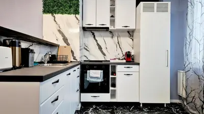 a kitchen with white cabinets and a black stove at Spacious 3 BDR City Pulse near Airport, The Mall, Arena 8888 by KeyBox in Sofia
