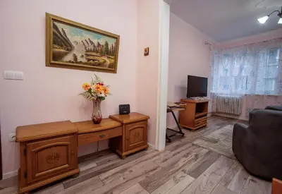 a living room with a vase of flowers on a desk at Alex's Charming Apartment by NDK in Sofia