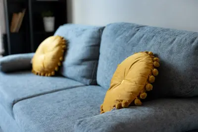 a blue couch with two yellow pillows on it at 1 min from NDK and Vitoshka street in Sofia