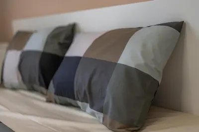 a row of pillows sitting on top of a bed at 1 min from NDK and Vitoshka street in Sofia