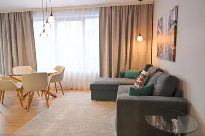 a living room with a couch and a table at 2 Luxurious one bedroom apartments 5 minute walk from the Gondola station in Bansko