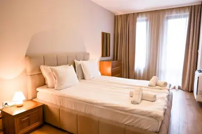 a bedroom with a large bed with towels on it at 2 Luxurious one bedroom apartments 5 minute walk from the Gondola station in Bansko