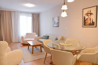 a living room with a glass table and chairs at 2 Luxurious one bedroom apartments 5 minute walk from the Gondola station in Bansko