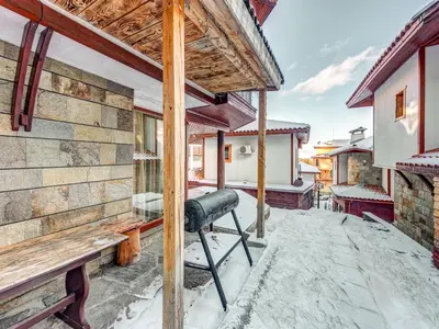 a balcony of a house with snow on the ground at Raikovski Livadi Mountain Villas Pamporovo in Smolyan