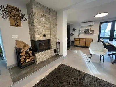 a living room with a fireplace and a dining room at Къща за гости Алино Хаус in Alino