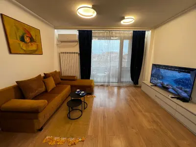 a living room with a couch and a flat screen tv at Barcelona 2BDR Cozy Apt w Working Space near Metro in Sofia