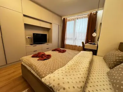 a bedroom with a large bed and a television at Barcelona 2BDR Cozy Apt w Working Space near Metro in Sofia