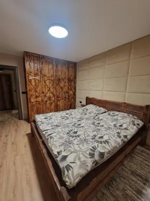 a bedroom with a bed with a wooden headboard at WoodLux in Pamporovo
