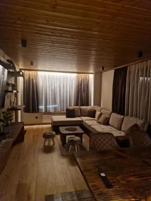 a living room with a couch and a large window at WoodLux in Pamporovo