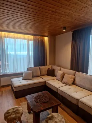 a living room with a couch and a table at WoodLux in Pamporovo