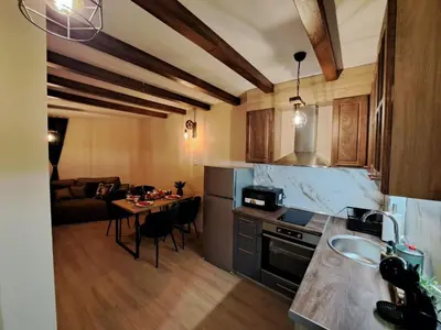 a kitchen and a living room with a table at Alpine Apart Pamporovo in Pamporovo