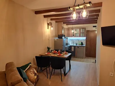 a living room and kitchen with a table and a couch at Alpine Apart Pamporovo in Pamporovo