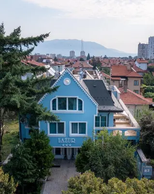 a blue house on top of a city at Family Hotel Lazur in Kyustendil