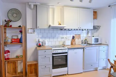 a kitchen with white cabinets and a stove top oven at Comfortable 1-Bedroom Apartments in Bansko - Close to Gondola by Flat Mаnаger in Bansko
