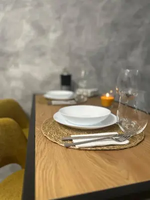 a wooden table with plates and glasses on it at Le Bijou МОЛ Плаза in Plovdiv