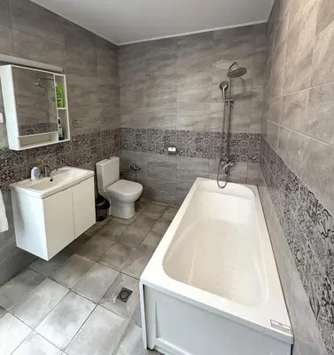 a bathroom with a tub and a toilet and a sink at Кольовата къща Тетевен in Teteven