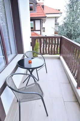 a balcony with a table and chairs on it at White Peaks 1BR Apartment Bansko by SI Stay in Bansko